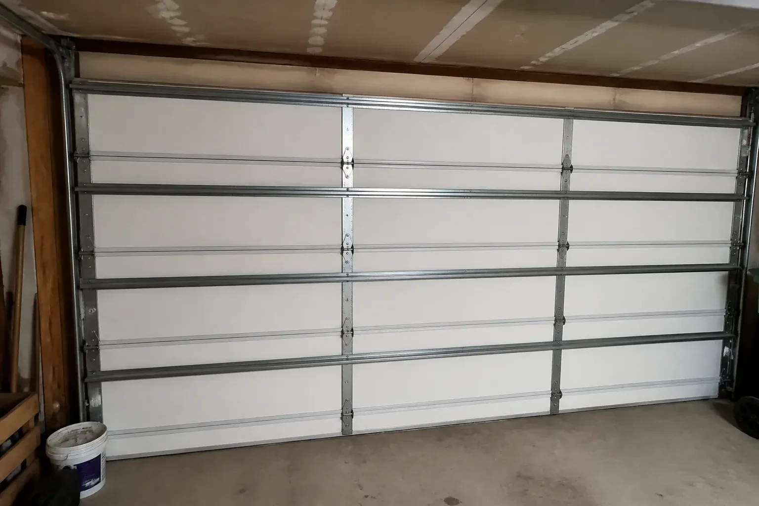 Interior of a closed sectional door with horizontal metal reinforcement struts. — Wind-Rated Garage Door Replacement, Innisfil